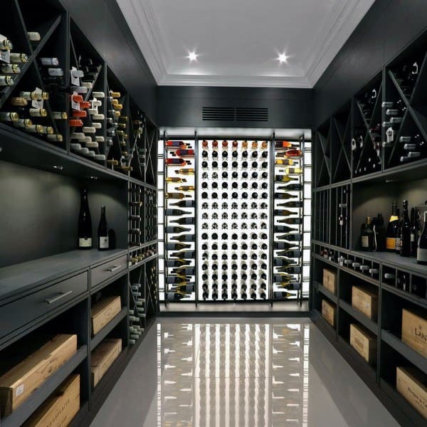 A modern wine cellar with an array of bottles on wooden racks and a sleek white wine display at the center