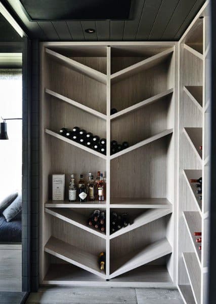 Sleek pantry with angled shelves designed for wine and liquor storage in a modern setting.