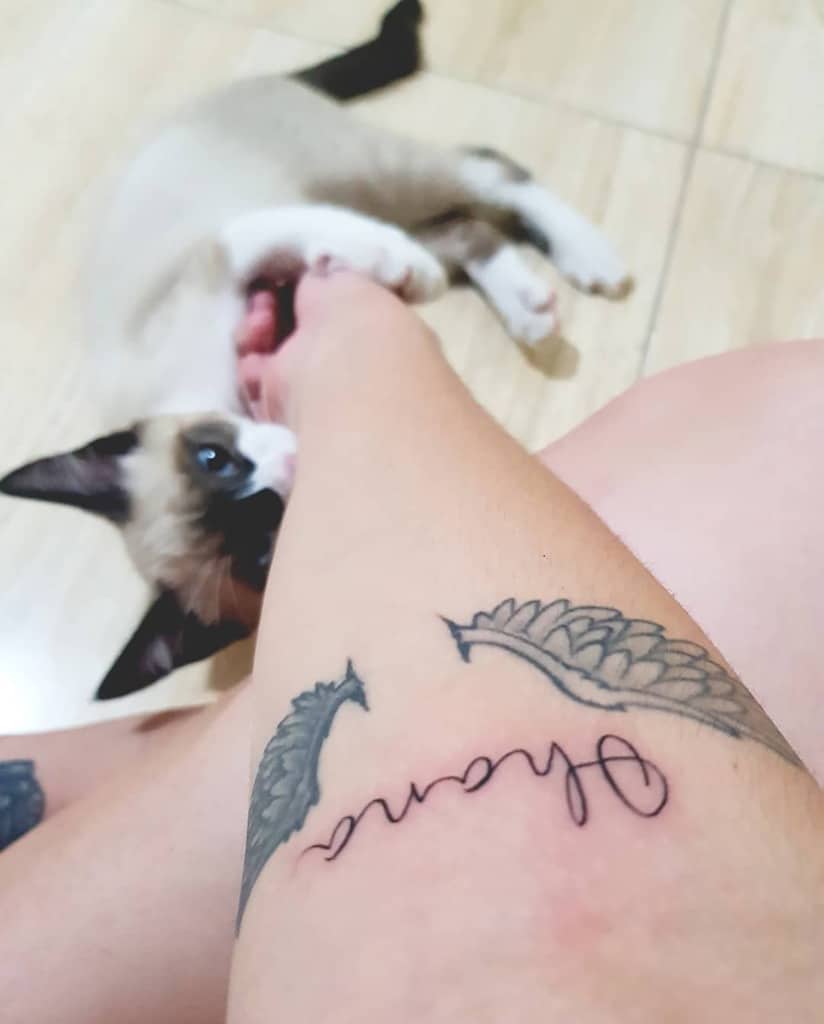 Delicate tattoo of the word 'Ohana' with a wing design, symbolizing family, protection, and unity.