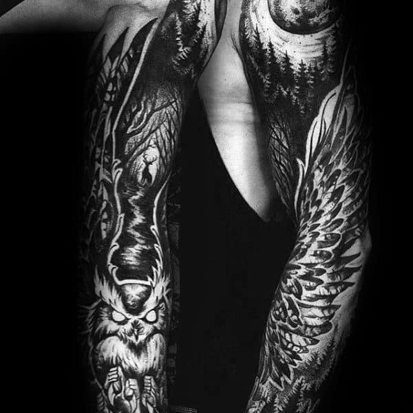 Dark forest-themed tattoo sleeve with a fierce owl, moonlit trees, and wide wings, symbolizing wisdom, mystery, and night power.