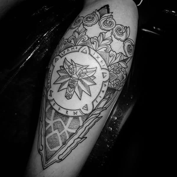 Linework Witcher tattoo on the forearm featuring the wolf medallion with runes, geometric patterns, and blooming roses in black ink.