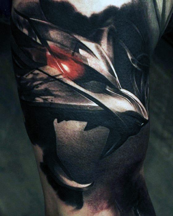 Dark and dramatic Witcher tattoo of the wolf medallion in a realistic style with metallic shading and a glowing red eye effect.
