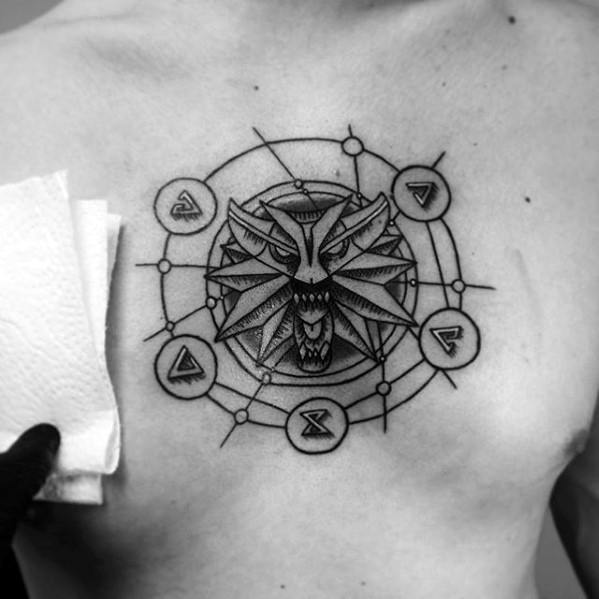 Geometric Witcher chest tattoo of the snarling wolf medallion surrounded by magical sign symbols connected by fine circular linework.
