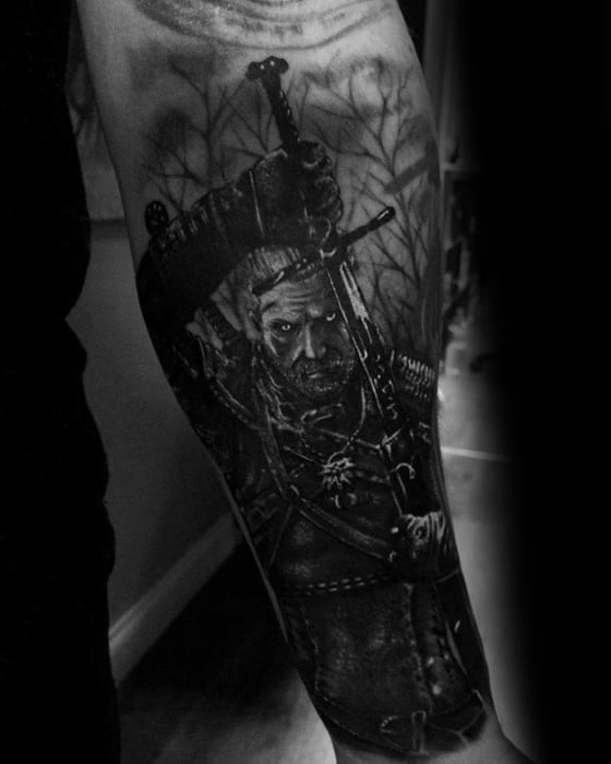 Realistic black and grey Witcher tattoo of Geralt drawing his sword in a forest setting, detailed with shadows and texture on the forearm.
