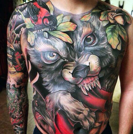 A detailed chest tattoo of a 
wolf, enveloped by vibrant leaves and complemented by colorful arm tattoos