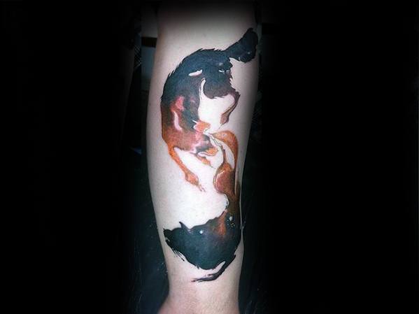 Yin-yang inspired tattoo of two wolves in motion, one dark and one fiery red, blending abstract shapes with fluid watercolor style.