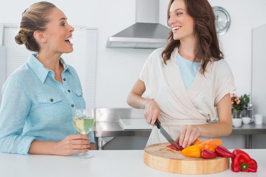 woman cooking while talking to her friend