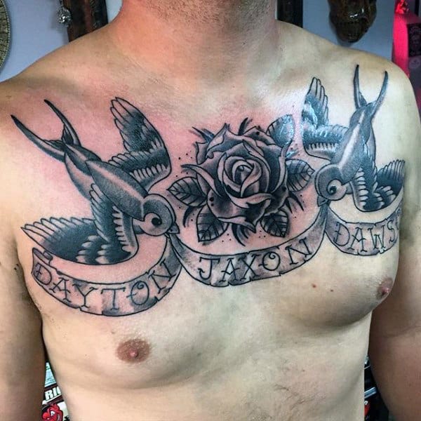 Chest tattoo of two sparrow birds holding a banner with a rose in the center