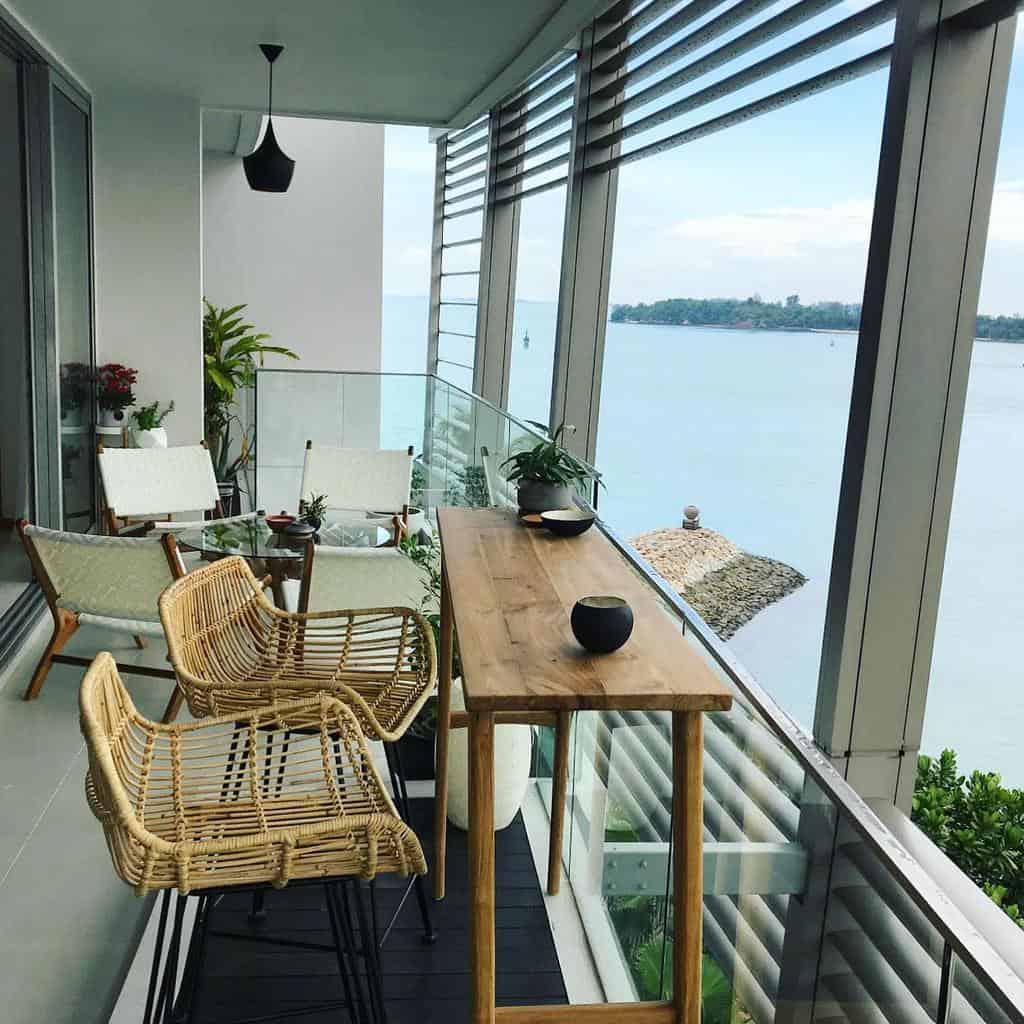 Modern balcony with wooden furniture, rattan chairs, and a scenic river view.