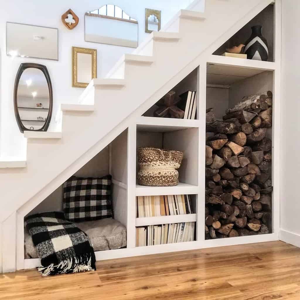 Under-stair storage with firewood, books, baskets, and a cozy nook on wood flooring.