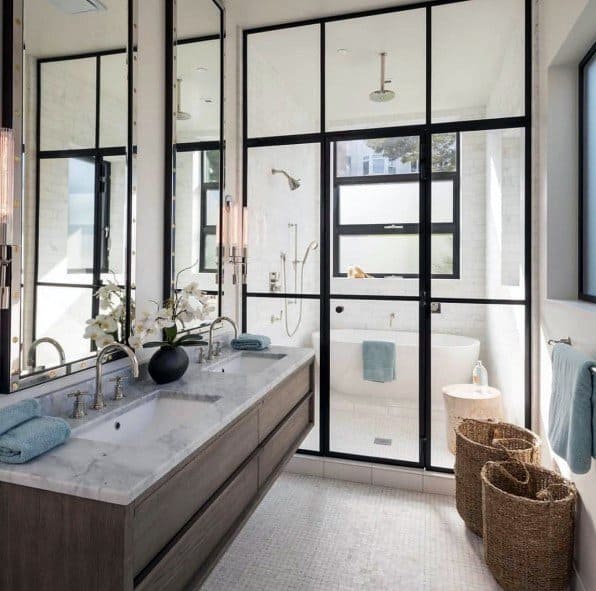 Wood vanity with marble top, large shower, and freestanding bathtub in a modern bathroom.