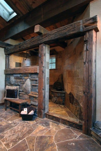 Rustic stone and wood shower with a cozy bench and basket on a stone-tiled floor
