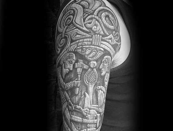 Black and grey Norse-inspired tattoo sleeve featuring intricate Viking artwork, knotwork patterns, and detailed depictions of ancient craftsmen.