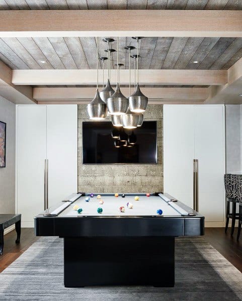 Modern game room with rustic wood ceiling, exposed beams, pool table, and pendant lighting.
