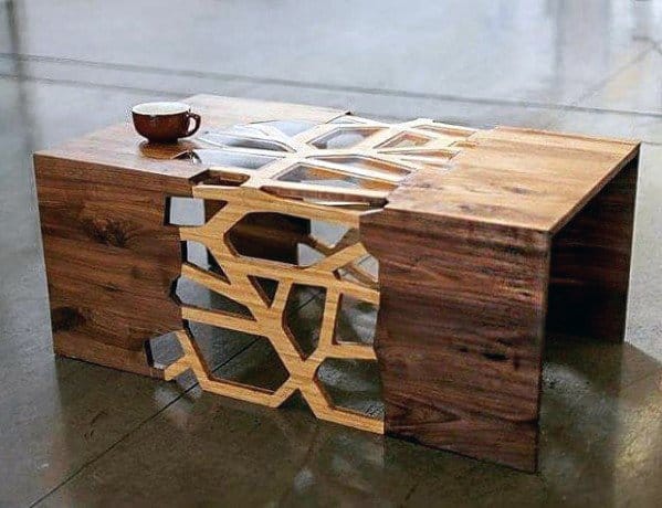 Wood coffee table with intricate geometric cutout design and glass inlay.