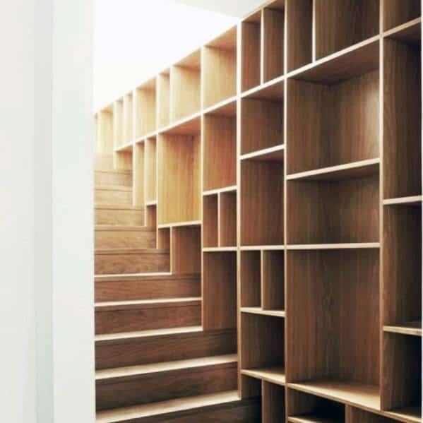 Wooden staircase with built-in wall shelves for storage in a modern, minimalist design.