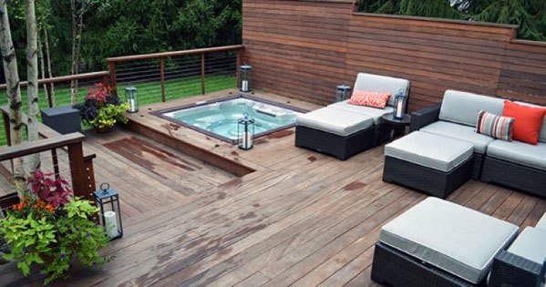 wood deck hot tub wicker sun lounge and sof privacy wall