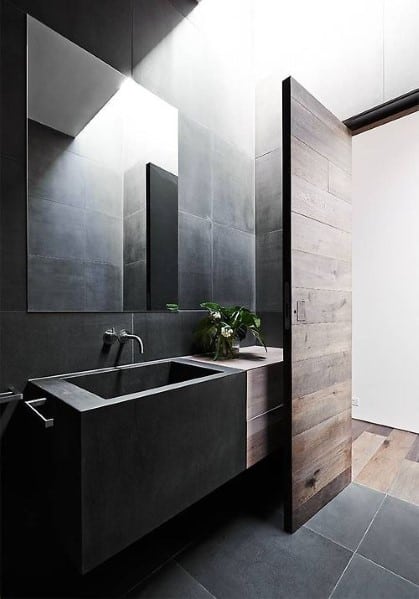 Modern bathroom with a sleek sink, mirror, and wooden door
