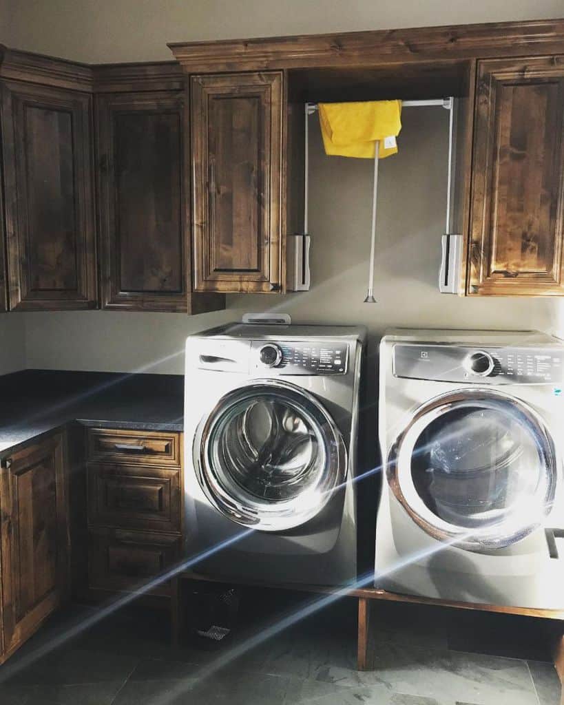 stained wood cabinet laundry room washer and dryer