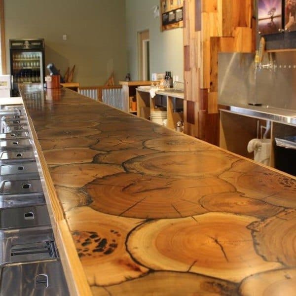 Bar top made from polished wood log cross-sections with natural rings and woodgrain details.