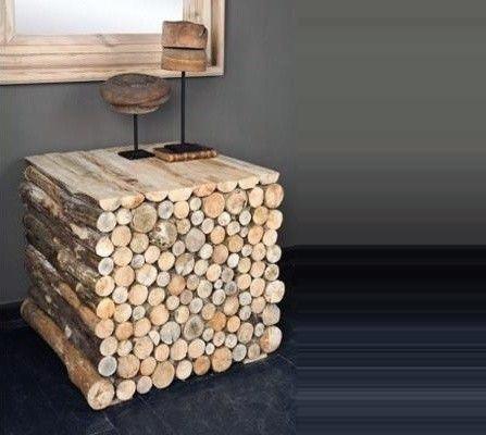 A square side table made of stacked firewood logs with a minimalist decor piece on top