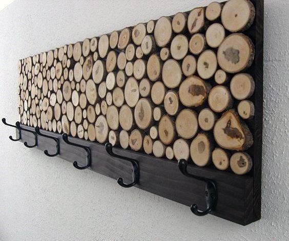 Wood log slice coat rack with black metal hooks, mounted on a rustic wooden board.