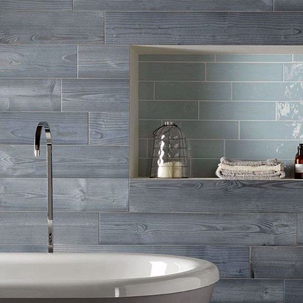 Bathroom with blue wood-look tiles, built-in shelf, and modern bathtub.