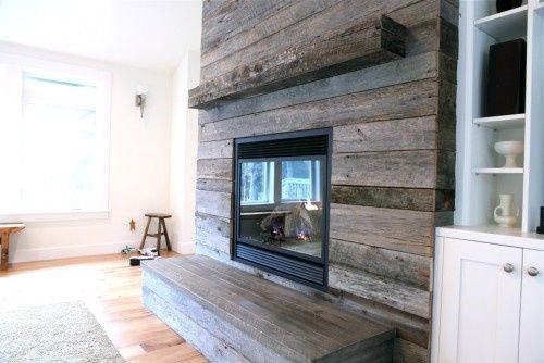 Modern fireplace with reclaimed wood paneling, built-in shelving, and minimalistic decor.