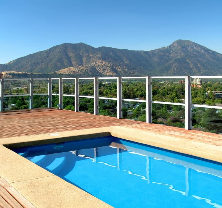 wood platform above ground pool with railings deck