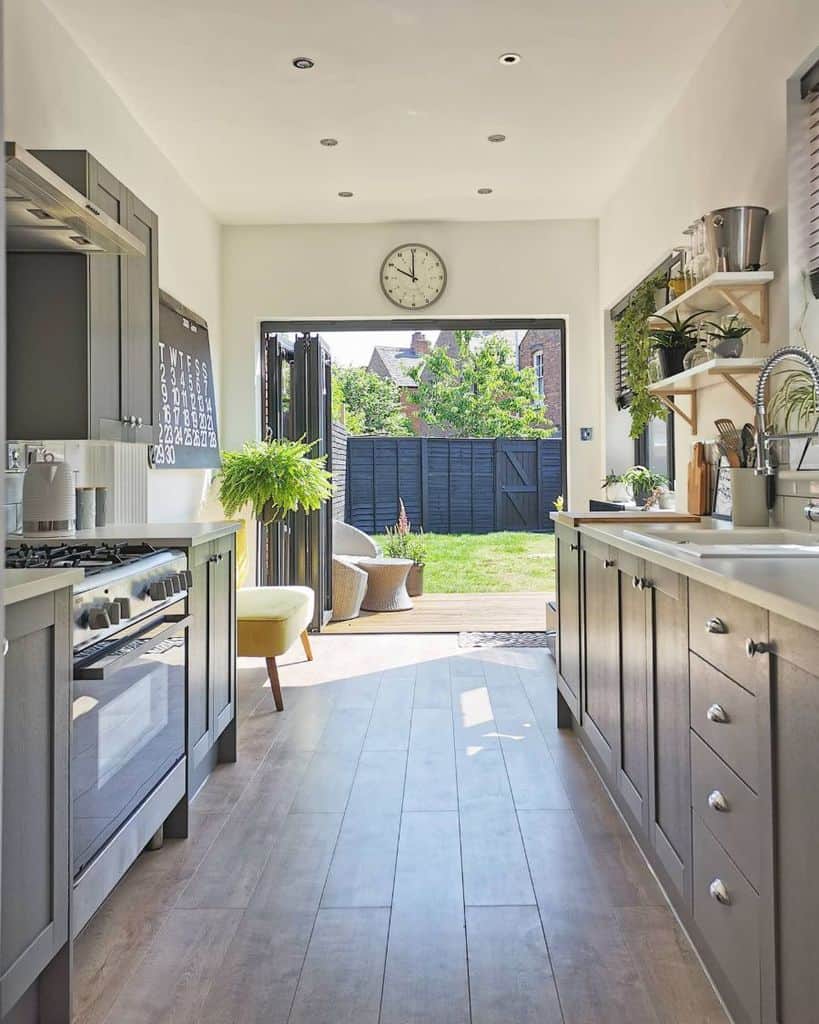 gray cabinet galley kitchen open to backyard