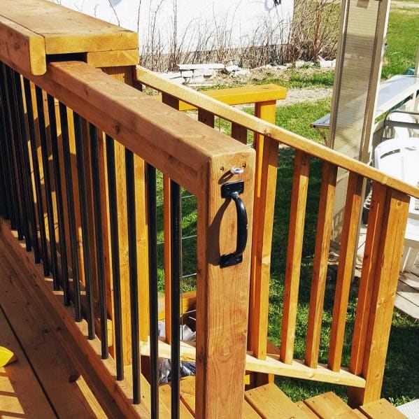 Sunny day on a wooden deck with railing, metal bars, and a gate handle
