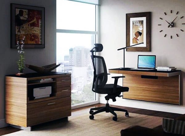 Modern home office with a chair, desk, laptop, and artwork. Cityscape visible through large window