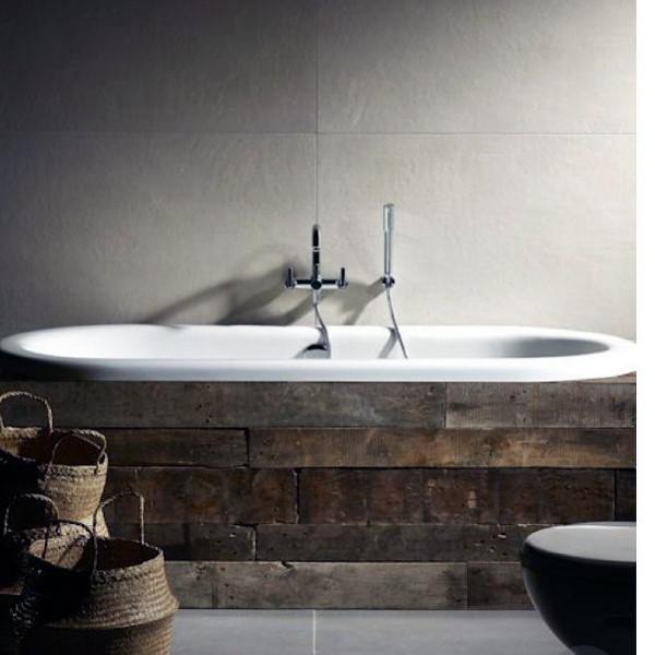 Rustic bathtub with wooden paneling, baskets nearby in a minimalist bathroom