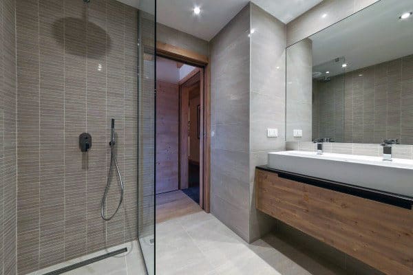 Modern bathroom with a glass shower, large mirror, and wooden vanity