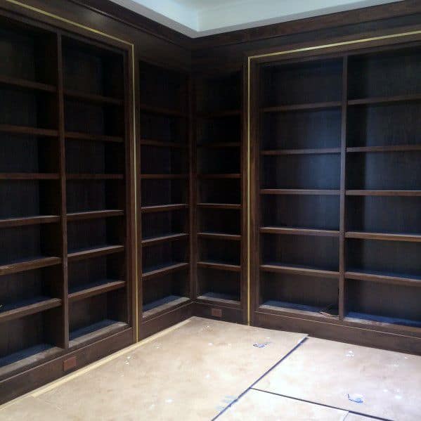Empty wooden bookshelves line the room with a light-colored floor
