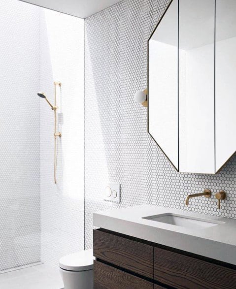 Dark wood vanity with white countertop, hexagonal mirror, and white hex tile wall.