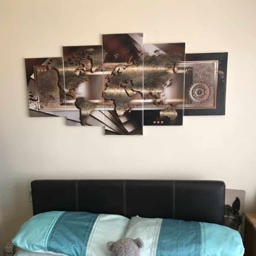 Bedroom with 3D world map wall art and black leather headboard.