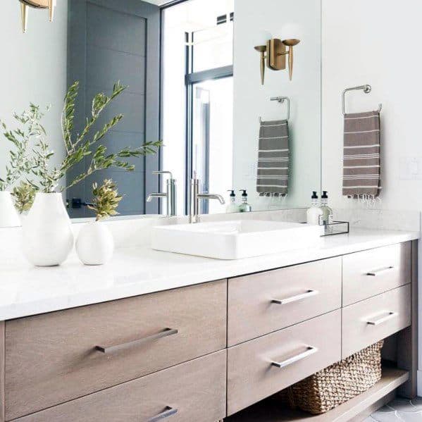 Modern wooden vanity with white countertop and decorative accents.