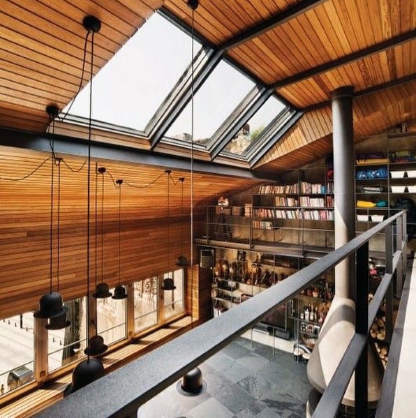 Living room with wooden ceiling, skylights, modern shelving, and industrial decor.