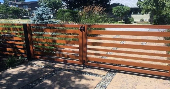 Modern wooden driveway gate with horizontal slat design.