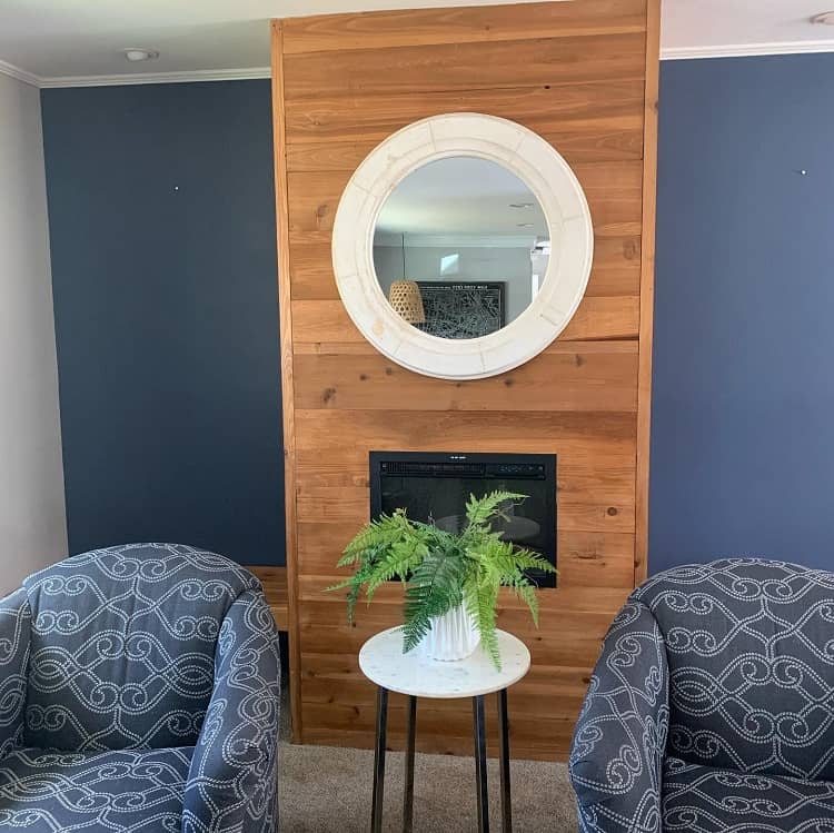 wooden floor to ceiling fireplace surround blue wall mirror