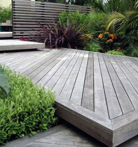 Walkway and wooden deck with greenery in a modern tropical garden setting