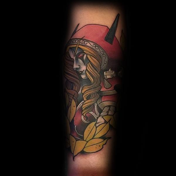 Tattoo of Sylvanas Windrunner from World of Warcraft, featuring a bold, stylized design with a red hood, golden leaves, and intricate armor, inked on the forearm.