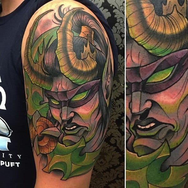 Colorful tattoo of Illidan Stormrage from World of Warcraft, featuring glowing green eyes, large horns, and vibrant shading, inked on upper arm.