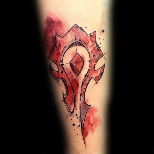 Sketch-style tattoo of the Horde emblem from World of Warcraft, featuring bold black lines and a red watercolor effect, inked on the forearm.