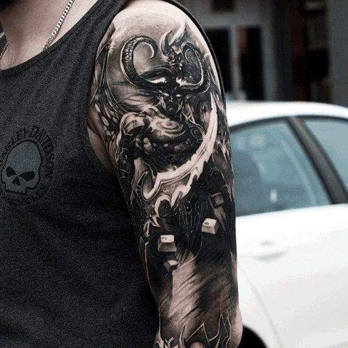 Black and grey tattoo of Illidan Stormrage from World of Warcraft, featuring his iconic horns, glowing eyes, and warglaives, inked on the upper arm.