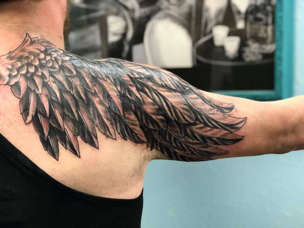 Detailed angel wing tattoo, with bold shading and intricate feathering for a dramatic and dynamic effect