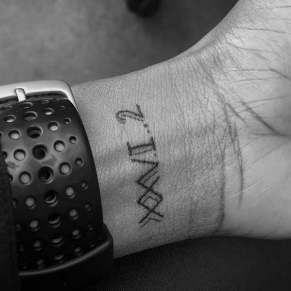 Small and minimalist wrist tattoo featuring Roman numerals XXVI.2, a subtle nod to completing a full marathon distance.