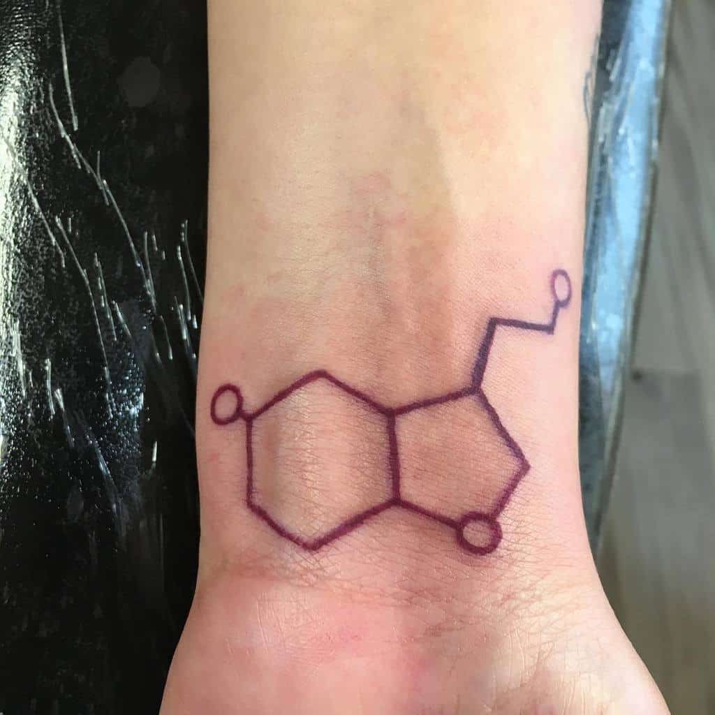 Tattoo of a chemical structure resembling serotonin on a wrist