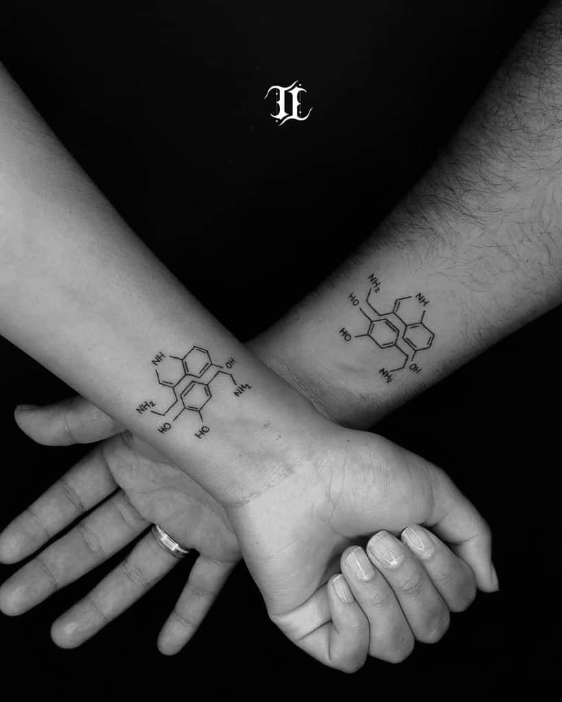 Minimalist matching serotonin molecule tattoos on wrists, symbolizing connection and happiness
